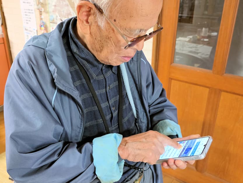 Galaxy A25を操作する90歳